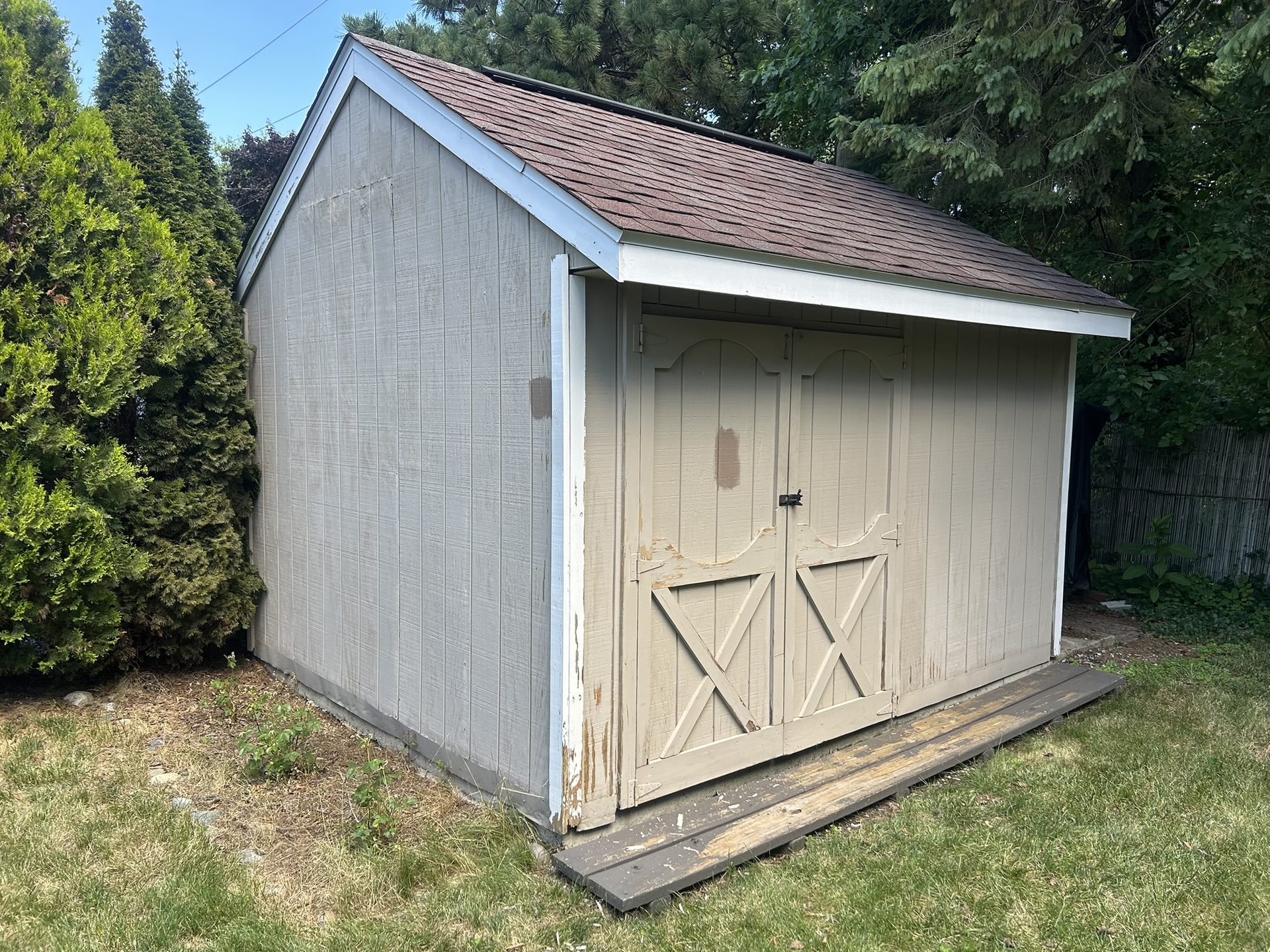Before: weathered board and batten shed with peeling paint