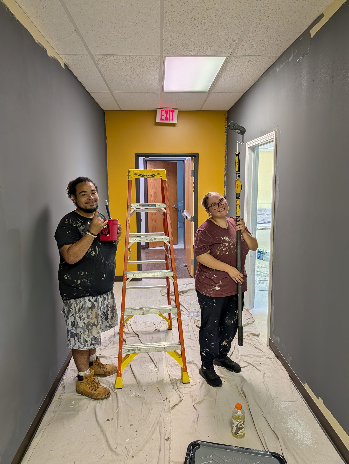 Poster frame: two Paint My House crew members on an interior job, ladder set