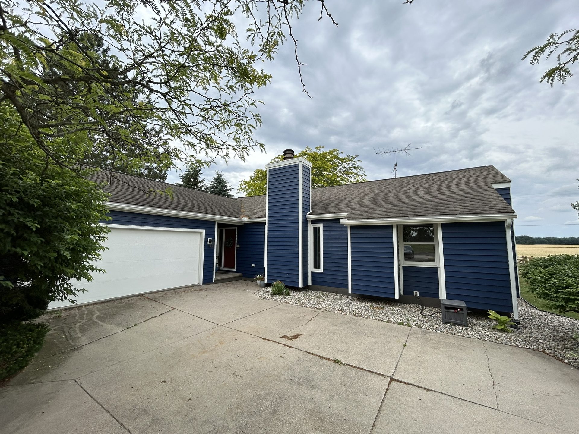 Finished exterior repaint, wood lap siding in deep blue with white trim